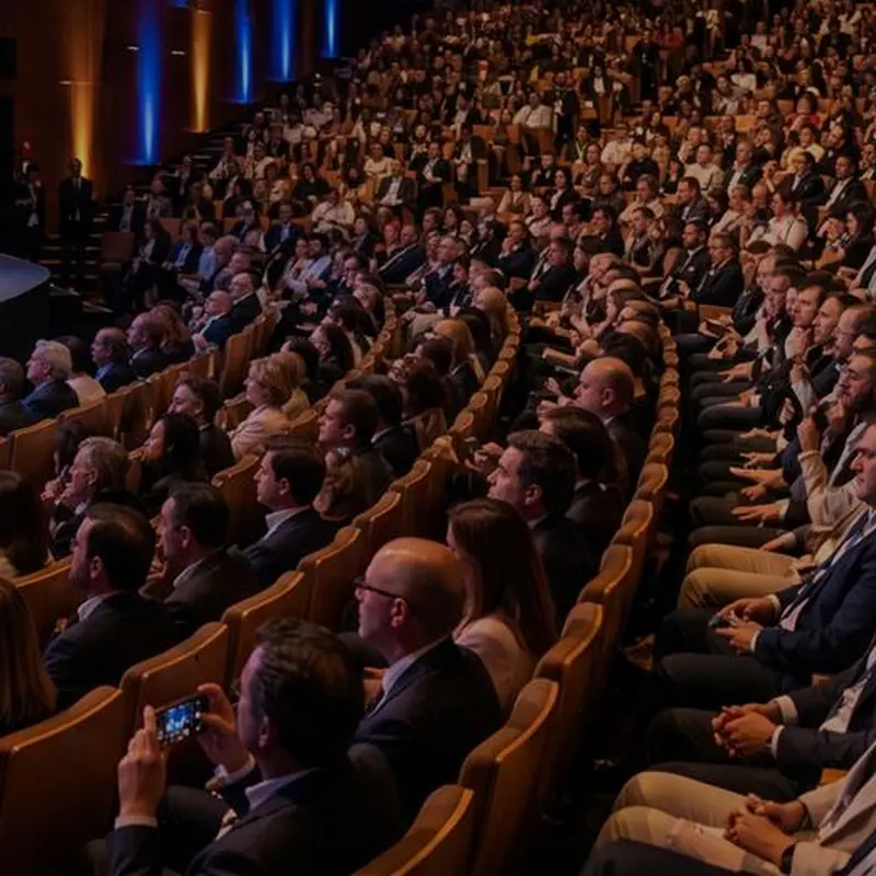Asistentes atentos en las gradas de un auditorio
